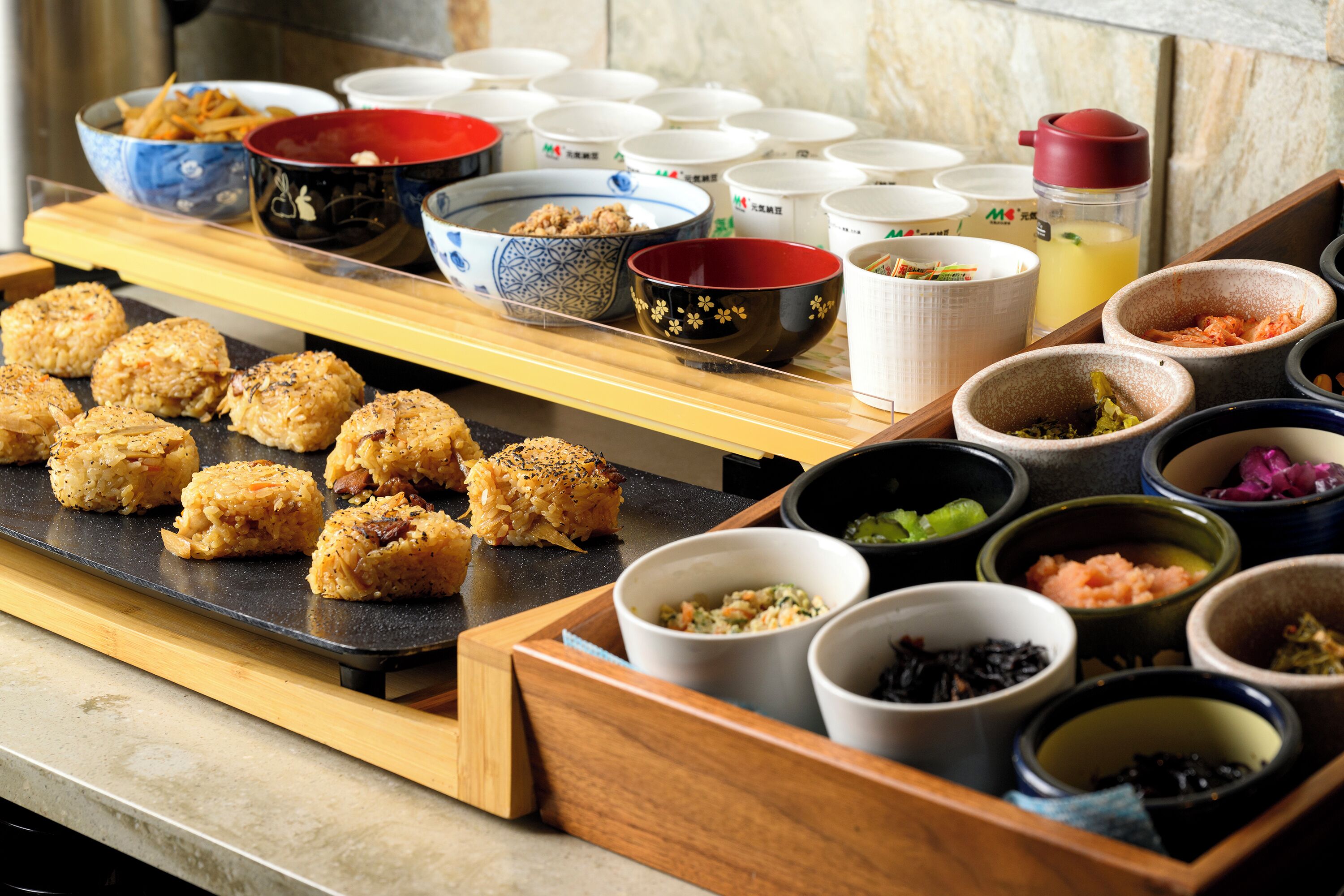 A buffet with various food items and small bowls of condiments.