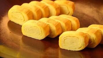 A wooden surface with several bread rolls.