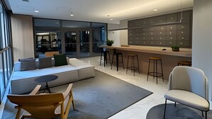 Un interior moderno con una zona de estar, un bar y vistas a otra habitación.