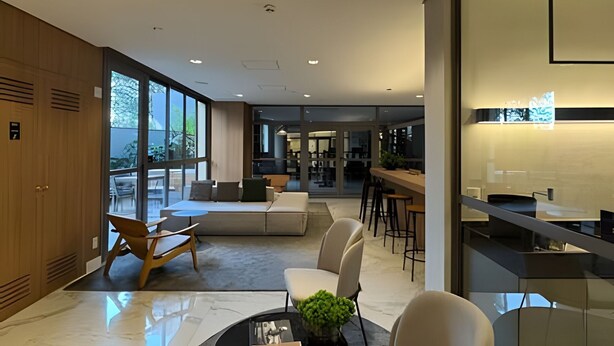 Un interior moderno con zona de estar, cocina y ventanas amplias.
