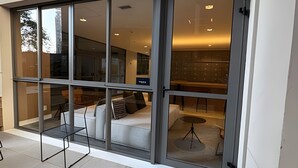 Un interior moderno con amplios ventanales, un sofá y una mesita.
