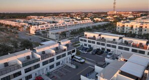 A multi-story parking structure with several levels of parking, surrounded by modern buildings. - Sunset Place (Homestead)