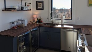 Eine moderne Küche mit einem großen Fenster, integrierten Geräten und einer Holz Arbeitsplatte.