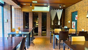 A restaurant with brick walls, wooden ceiling, and tables with chairs. - Kozuka Hisanoha (Hakone)
