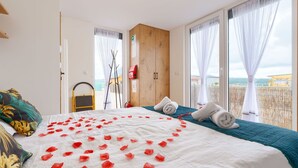 Hotellihuone, jossa on sänky, merinäköala ja puinen vaatekaappi.