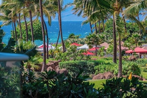 Ein tropisches Resort mit Palmen, Blick auf den Ozean und Gebäuden mit roten Dächern.
