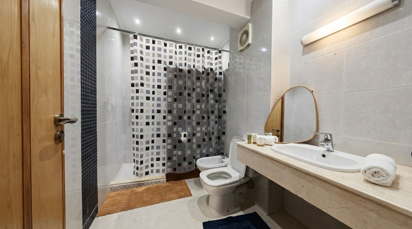 A modern bathroom with a shower, toilet, and sink.