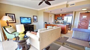 Una sala de estar con sofá, televisor y comedor con mesa y sillas.