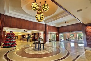 Eine Hotelhalle mit einer Rezeption, einem Weihnachtsbaum und einer runden Sitzecke.