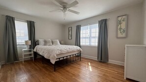 A bedroom with a bed, a ceiling fan, a bedside table, a lamp, and a radiator. - Close to Hospitals, Masters & Downtown (Augusta)