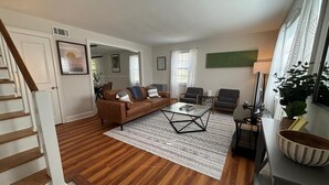 A living room with a brown sofa, a glass coffee table, and a patterned rug. - Close to Hospitals, Masters & Downtown (Augusta)