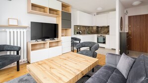 Una sala de estar moderna con televisor, sofá y mesa de centro de madera.