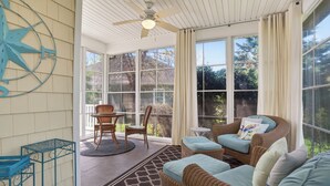 A sunroom with wicker furniture, a ceiling fan, and large windows. - One Level Rehoboth Beach House Steps to Pool (Rehoboth Beach)