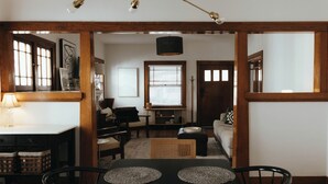 A dining area with a table, chairs, and a chandelier. There is a window with blinds and a door in the background. - Vintage Style Home Near Downtown | W&D + Patio (Wichita)