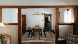 A dining area with a round table, chairs, a chandelier, and a view into the kitchen. - Vintage Style Home Near Downtown | W&D + Patio (Wichita)