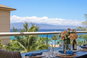 Ein Esstisch mit Blick auf das Meer und die Berge.
