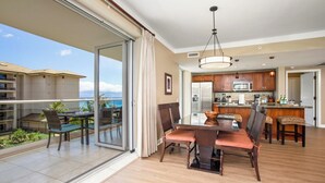 Una habitación de hotel moderna con balcón, comedor y cocina.