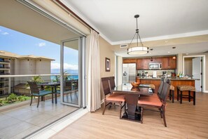 Une chambre d’hôtel moderne dotée d’un balcon, d’un coin repas et d’une cuisine.