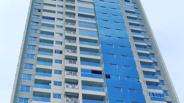 A high-rise building with multiple floors, balconies, and a modern architectural design.