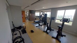 A gym with treadmills, elliptical machines, and free weights.