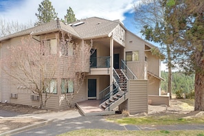 A two-story house with a covered porch, a staircase, and a small front yard. - River Ridge 429B- Hotel style room close to Mt Bachelor, hiking trails, and Old Mill District (Bend)