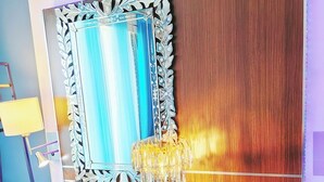 A room with a vanity, a mirror, a chandelier, a fluffy rug, and a wooden panel wall. - Blue Bunny-Eared Stay | Ocean View | 2min to Beach (Surfers Paradise)