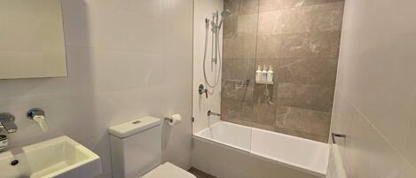 Un baño con inodoro, lavabo y bañera.