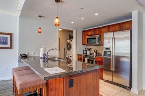 A modern kitchen with a central island, stainless steel appliances, and pendant lighting. - 2 Honua Kai Villas | Ocean View | Sleeps 10 | Free Car w/ 6+ Nights | ML-2966 (Lahaina)