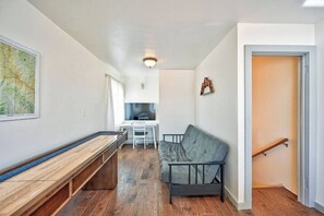 Um espaço compacto com um banco, sofá, mesa de jantar e cozinha.