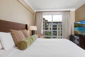 A hotel room with a large bed, a TV, a window with curtains, and a view of a building. - 2 Honua Kai Villas | Ocean View | Sleeps 10 | Free Car w/ 6+ Nights | ML-3068 (Lahaina)