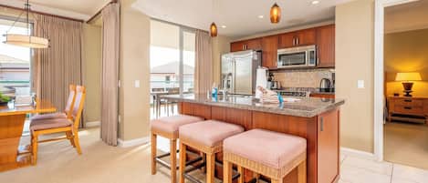 A modern kitchen with a central island, wooden cabinets, and stainless steel appliances.