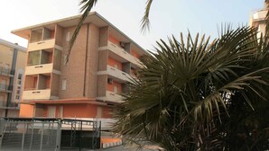 Un edificio a più piani con balconi e un ingresso carrabile.