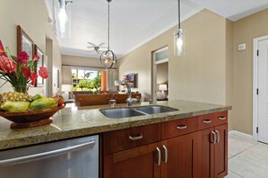 A kitchen with granite countertops, stainless steel appliances, wooden cabinets, and a central island with a sink. - 2 Honua Kai Villas | Resort View | Sleeps 14 | Free Car w/ 6+ Nights | ML-3080 (Lahaina)