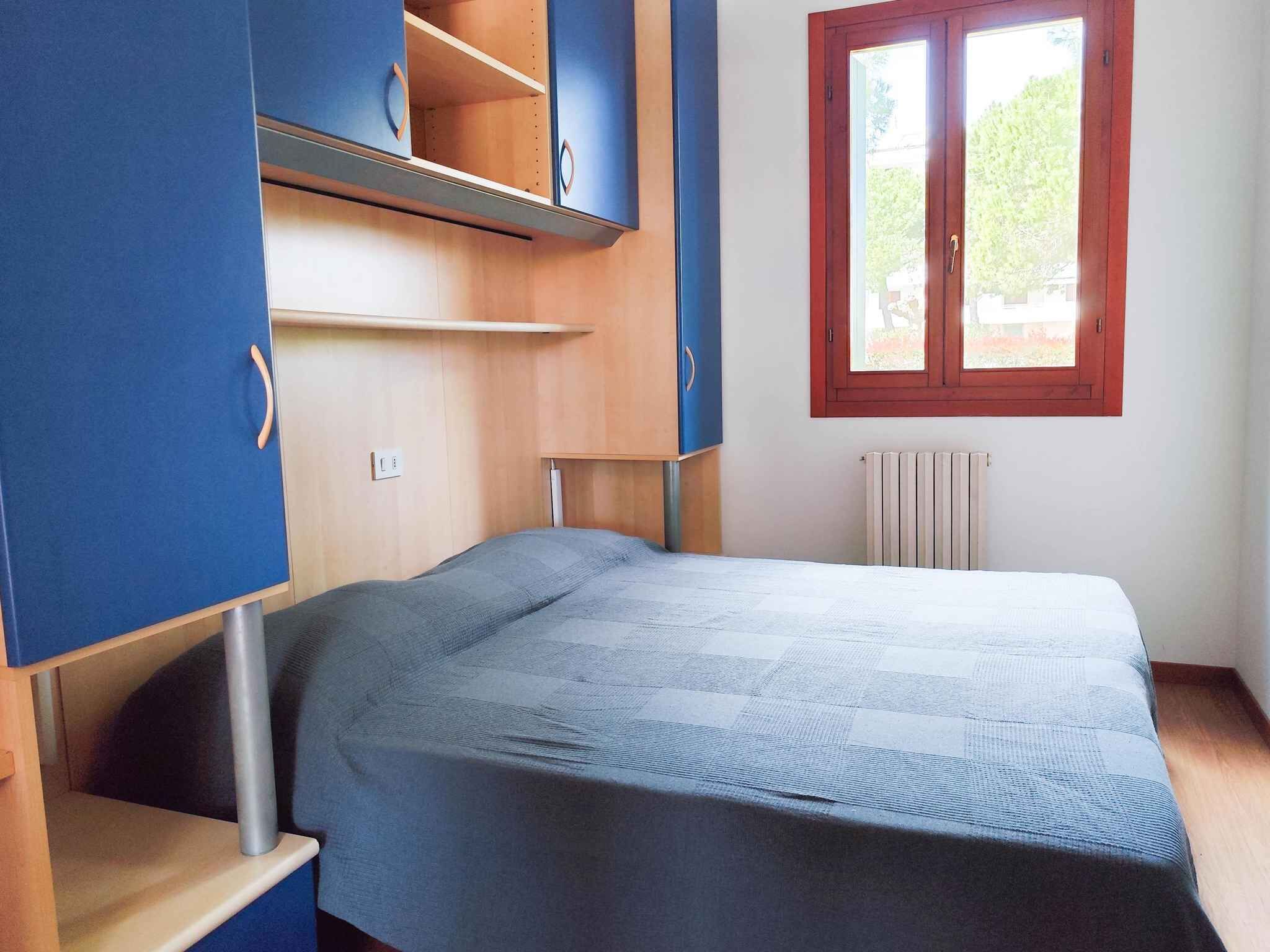 Een slaapkamer met een bed, een radiator, een raam en inbouwgarderobes.