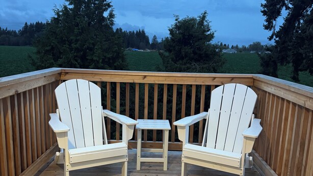 A wooden deck with two white Adirondack chairs and a small table. - Moonstruck Studio: In Wine Country (Newberg)