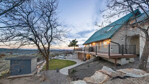 A house with a balcony, a stone pathway, and a view of the landscape.