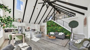 A spacious living area with a staircase, a kitchen, and a dining area.