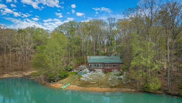 A cabin by a lake surrounded by trees. - Lakefront, Private Dock, Water Toys, Sunset Views! (Jefferson City)