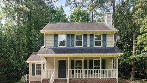 A two-story house with a front porch, a chimney, and a satellite dish. - Adorable home between Duke and UNC alongside trails (Durham)