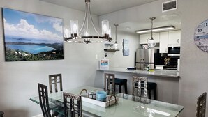 A modern kitchen with a glass dining table, stainless steel appliances, and a view of a coastal landscape. - Starfish Stay | Tranquil Pool | Directly Across From Beach (Corpus Christi)