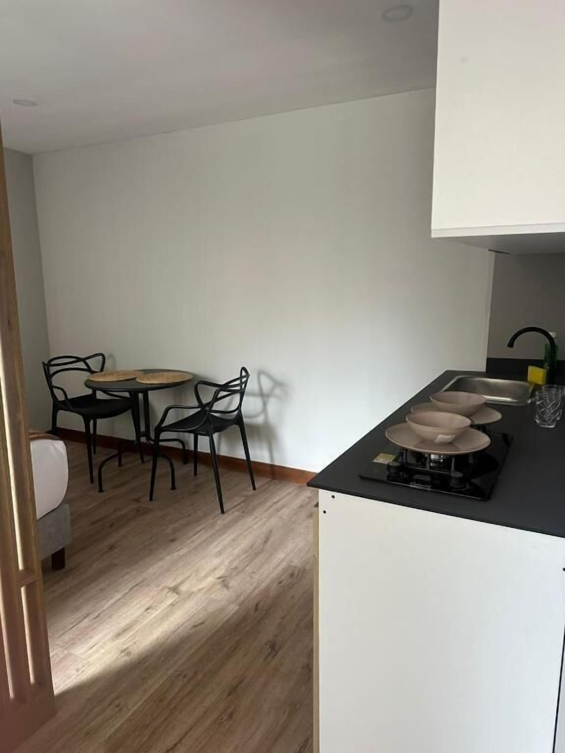 Une cuisine compacte avec un coin repas, une petite table et des chaises.
