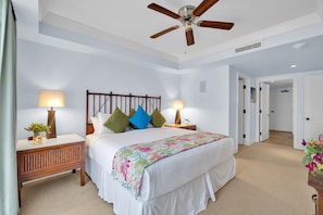 A bedroom with a bed, two bedside tables, a ceiling fan, and a door leading to another room. - 3 Honua Kai Villas | Ocean Front | Sleeps 22 | Free Car w/ 6+ Nights | ML-3188 (Lahaina)