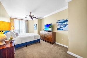A hotel room with a bed, a TV, a ceiling fan, and artwork on the walls. - 2 Honua Kai Villas | Ocean Front | Sleeps 16 | Free Car w/ 6+ Nights | ML-3191 (Lahaina)