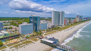 Eine Küstenstadt mit Wolkenkratzern, einem Strand und einer Promenade.