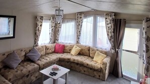 A living room with a sofa, a coffee table, and a chandelier.