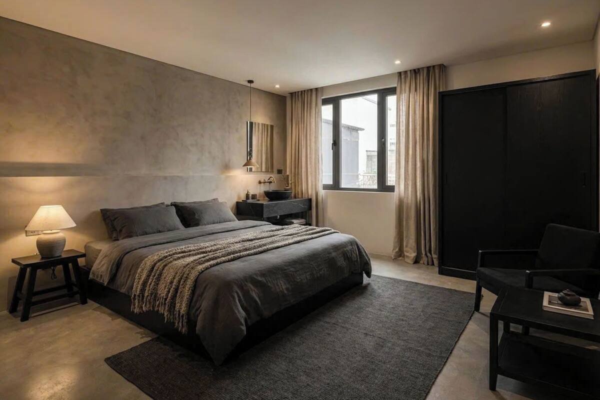 A modern bedroom with a large bed, bedside tables, a desk, and a window with curtains.