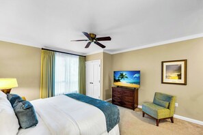 A hotel room with a bed, a television, a chair, a ceiling fan, and a door. - 2 Honua Kai Villas | Ocean Front | Sleeps 12 | Free Car w/ 6+ Nights | ML-3242 (Lahaina)