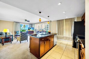 Ein modernes Hotelzimmer mit Kücheninsel, Essbereich und Meerblick.