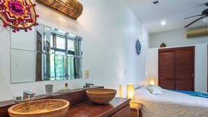 Ein Badezimmer mit einem Holzbadezimmerschrank, einem großen Spiegel und einem Fenster.