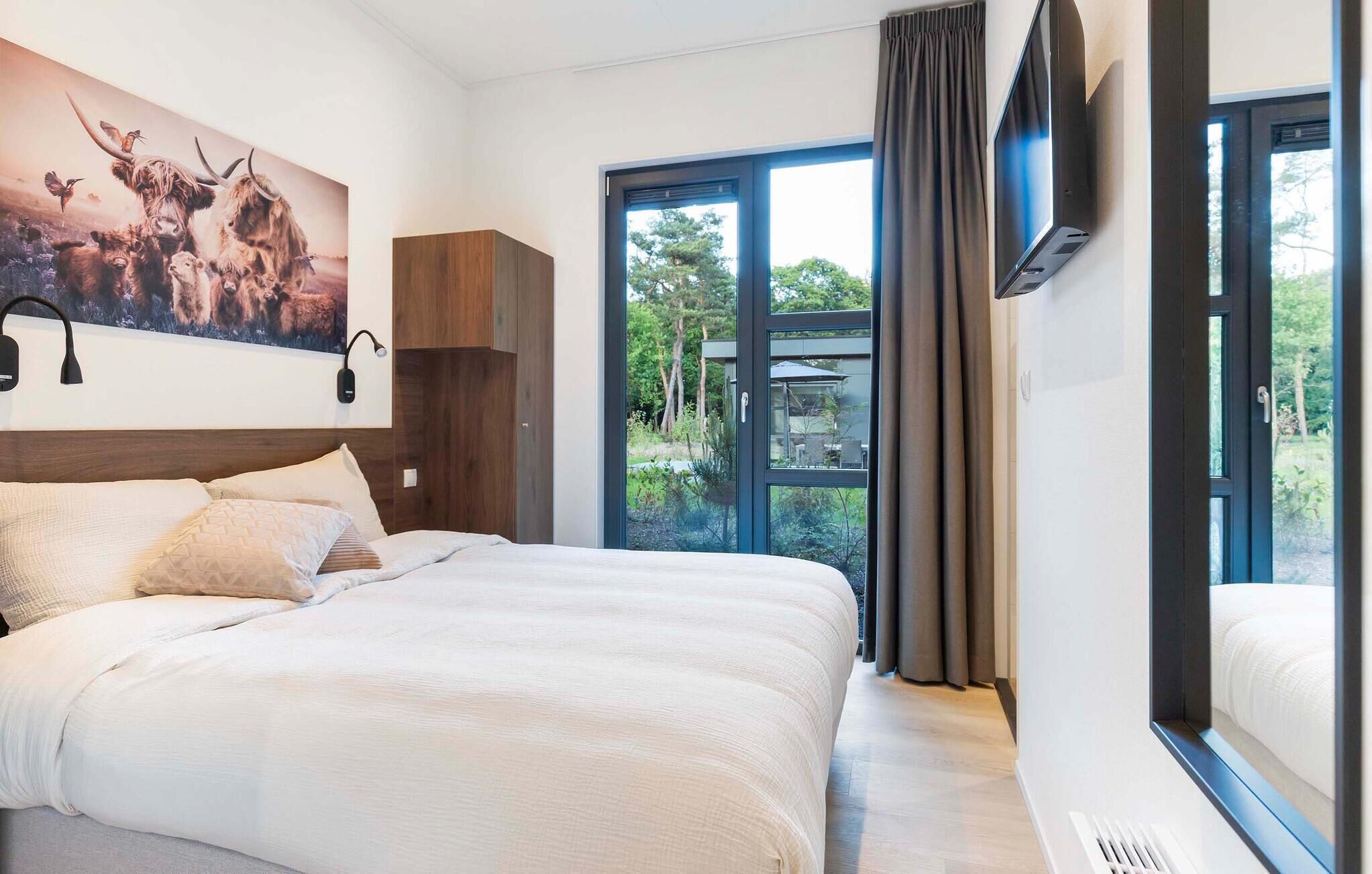 Een moderne hotelkamer met een groot bed, een wandgemonteerde televisie en uitzicht op de omgeving.